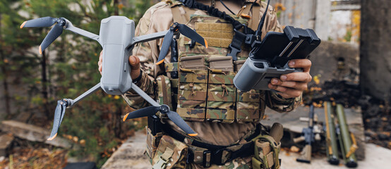 Concept military use of aerial drone in army. Soldier engineer holds an automatic quadrocopter in hands