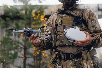 Soldier engineer holds an FPV quadrocopter and glasses view in hands. Concept military use of...