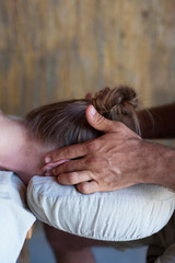Fototapeta premium Male massage therapist working with female client's ears. 