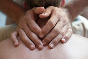 Massage therapist's hands. Male massage therapist working with a female client. 