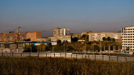 Fototapeta premium Urban landscape. Modern and Soviet architecture. Golden hour. Kazakhstan, 2022.
