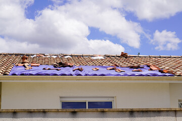 roof home covered with a tarp waiting for the roofing company to fix after thunderstorm - obrazy, fototapety, plakaty