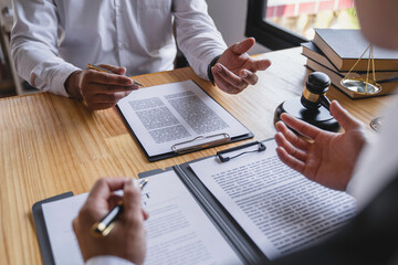 The lawyer working with a client discussing contract paper, a Business lawyer working about legal...