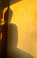 abstract shadow of buddha statue on wall with light of Sunrise