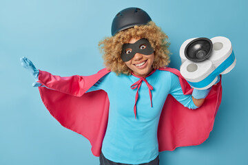 Horizontal shot of positive female superhero holds plunger with toilet paper around wears...