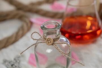Fototapeta na wymiar goulot d'une jolie bouteille avec une décoration de corde avec un bouton de bois avec en arrière plan un verre de martini