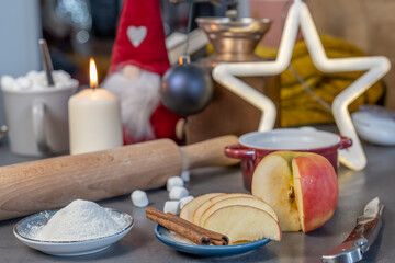 Obraz na płótnie Canvas ensemble d'ingrédients pour une tarte aux pommes avec des la cannelle dans un décor en fond flou de noel