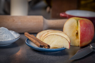cannelle et pomme coupée dans une soucoupe pour préparation de gateau de fête avec un décoration en fond flou