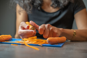 épluchage de carottes pour la réalisation d'un plat en gros plan avec fondu au flou
