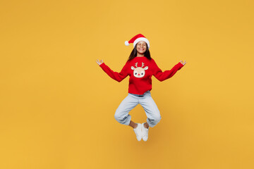 Merry little kid teen girl 13-14 year old wear red xmas sweater Santa hat posing jump high hold...