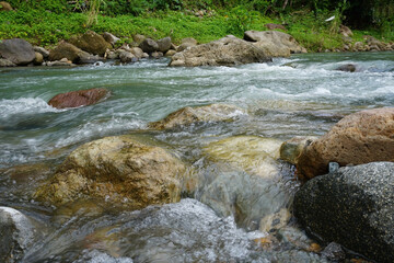 Naklejka na ściany i meble river with rocks in tropical indonesian nature 