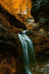 Eden falls waterfall floes down the rocky cliff at Lost Valley State Park in Arkansas during Autumn season. 
