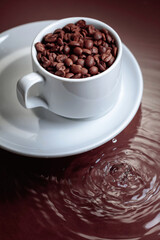 Cup with coffee beans on a brown background.
