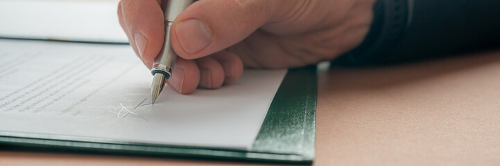 Caucasian male hand signing a document