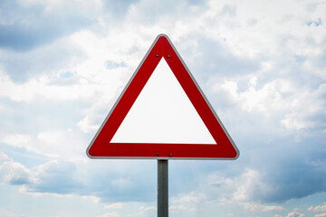 traffic sign in triangle shape with blue cloudy sky