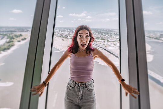A girl with a phobia and fear of heights screams and reacts emotionally on the observation deck of the TV tower. Psychological challenge