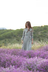 Beautiful woman with long dark hair in a dress in a lavender field.