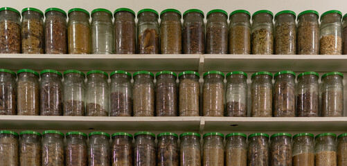 shelves with glass jars full of herbs in a Moroccan herbalist, traditional remedies, 
