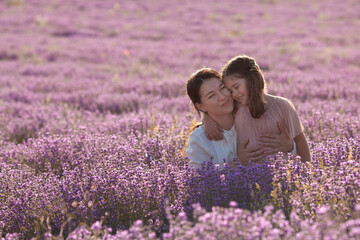 Portrait of a mother with her daughters on a background of lavender
