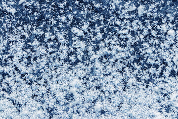 Fototapeta na wymiar Big fluffy snowflakes on the surface of the ice. Winter and Christmas background