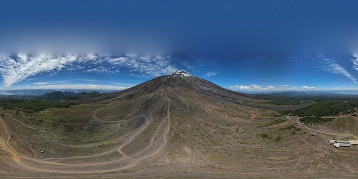 Imagen aérea panoramica en 360 grados del volcan villarrica, con cielo azul y nubes. Ubicado en villarrica pucón en Chile. Foto captada desde dron dji air2s