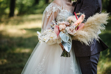 The bride and groom holds a wedding big vintage bouquet. The bouquet with flowers, roses, calla and...
