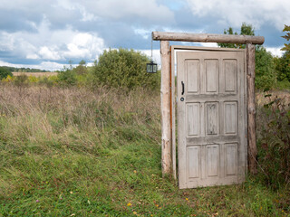 Unlocked door that leads to nowhere, copy space. Old mystery portal in the open field