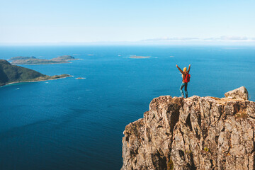 Hiker woman on mountain cliff edge over sea travel in Norway healthy lifestyle success motivation...