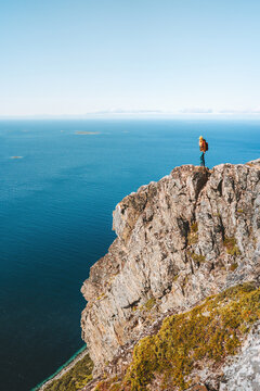 Traveler woman on cliff hiking mountains in Norway Travel Lifestyle adventure active vacations outdoor healthy lifestyle