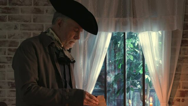18th century man opens a letter and reads it