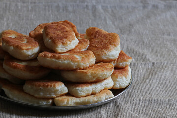 Traditional Ukrainian food - pies with potatoes. Many pies on a metal plate