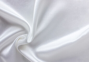White satin fabric as background. Closeup of rippled white silk fabric with copy space. Satin...