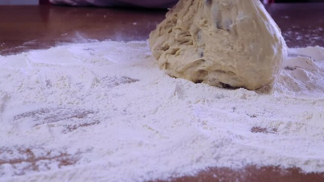 The hands of a Jewish woman sprinkle flour on a baking table