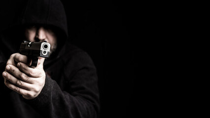 Man with gun, pointed at the camera