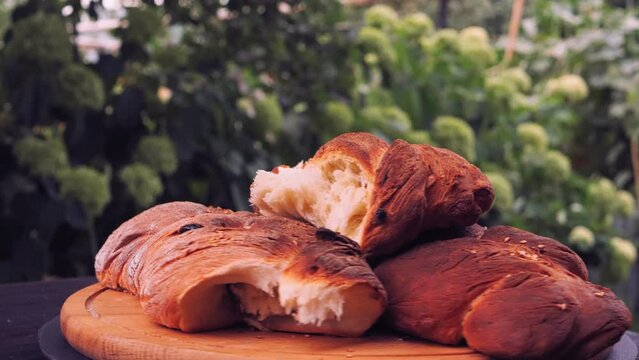 Freshly baked fried challah with raisins is rotated in a circle on a wooden board
