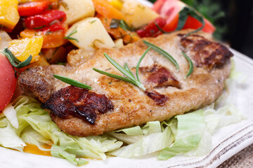 Joint of pork with baked potatoes and fresh vegetables