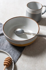 Empty bowl plate and mug with napkin and grey background, set up ready for the photoshoot, natural lighting