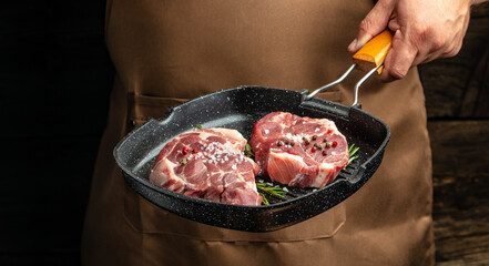 Fresh raw beef steaks with rosemary and pepper on grill pan. Culinary, cooking concept. Long banner format