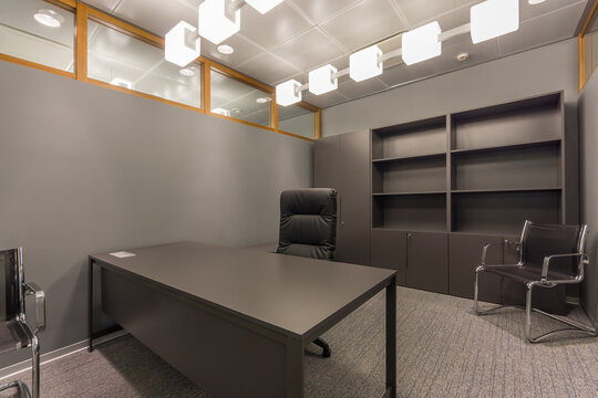 Office space with gray walls and floor decor, and dark gray furniture.