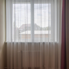 background window in the room with curtains and tulle