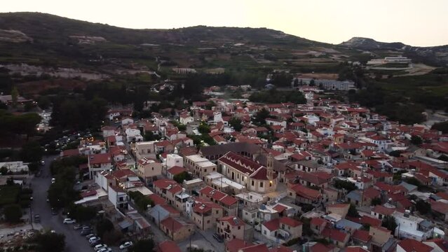 Aerial drone footage of traditional countryside village Omodos, Limassol, Cyprus. 360 view of Timios Stavros (Holy Cross) monastery, ceramic tiled roof houses and cobbled narrow streets from above.