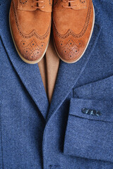 Top view brown suede derby shoes with blue tweed blazer and beige sweater. Casual men autumn...