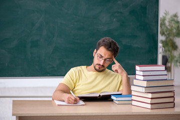 Young male student preparing for exams in the classroom