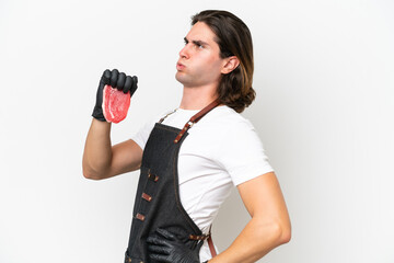 Butcher handsome man wearing an apron and serving fresh cut meat isolated on white background suffering from backache for having made an effort