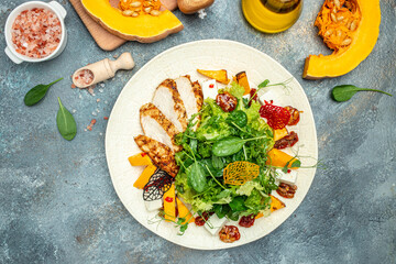 keto meal fresh salad with grilled chicken fillet, feta cheese, caramelized pumpkin, superfood concept. Healthy, clean eating, place for text, top view