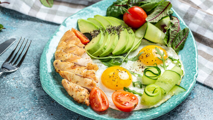 Breakfast with chicken grilled fillet with salad fresh tomatoes, cucumbers, eggs and avocado. Keto Paleo diet menu. top view