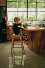 Fototapeta premium Little boy child drinks coconut water from a fresh coconut.