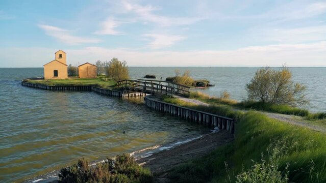 View of an ancient building along the Comacchio lagoon at sunset, near the town of Comacchio known as the "little Venice". Valleys of Comacchio. 
 Delta del Po 'park. Emilia - Romagna. Italy. 