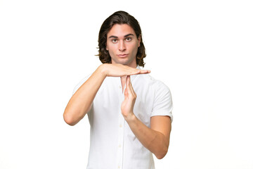 Young caucasian man isolated on green chroma background making time out gesture