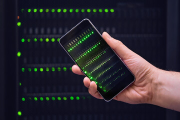 Mobile phone in the hands of a man at the server for data storage, close-up